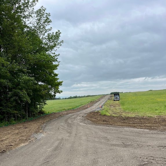 New gravel access road cut through farmland for a cell tower site