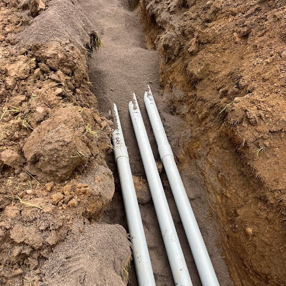 Underground utility conduit laid in a trench for a cell tower site